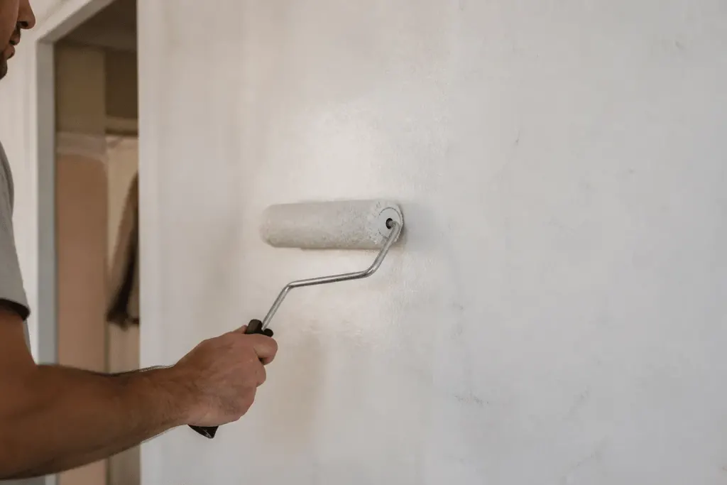 Rouleau colle appliquee sur mur blanc avant pose papier
