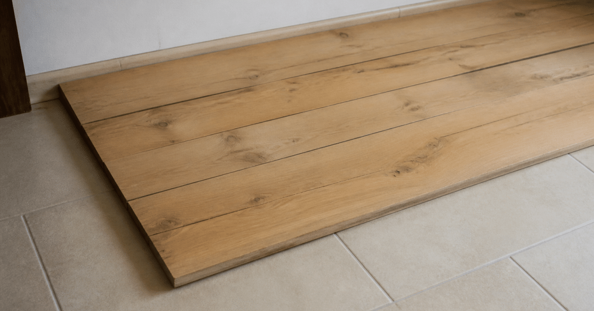 Planches de bois posees directement sur carrelage beige au sol