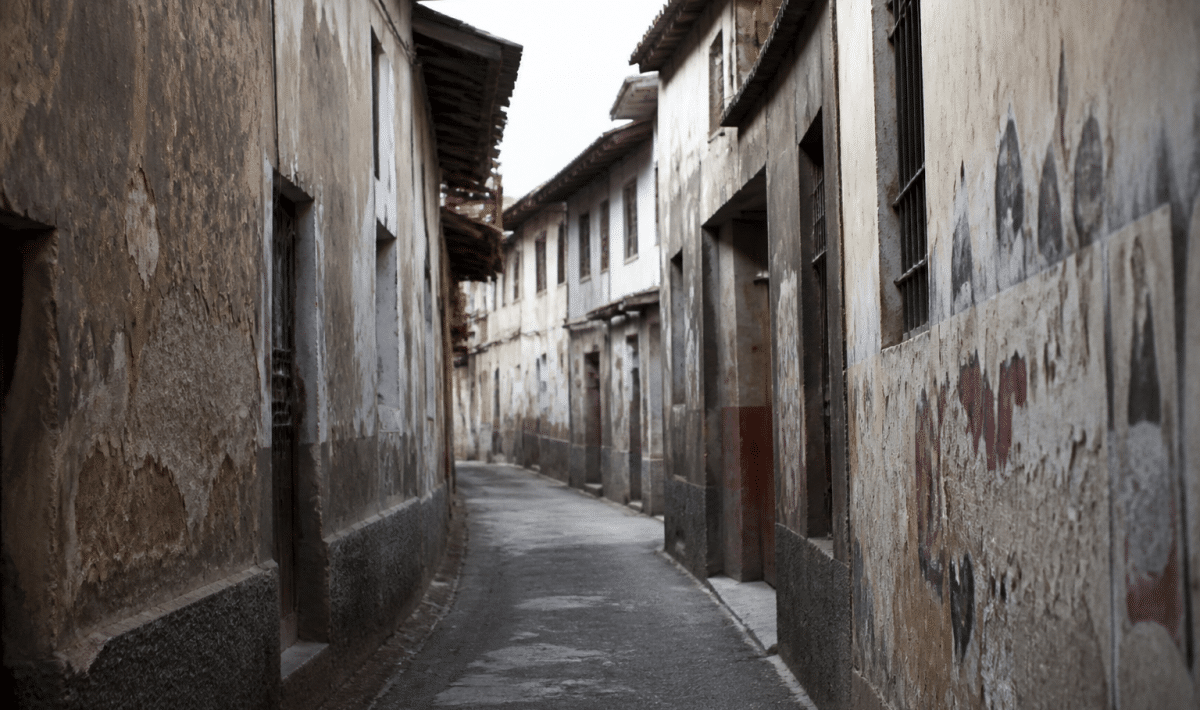 Rue etroite avec facades degradees et graffitis sur murs