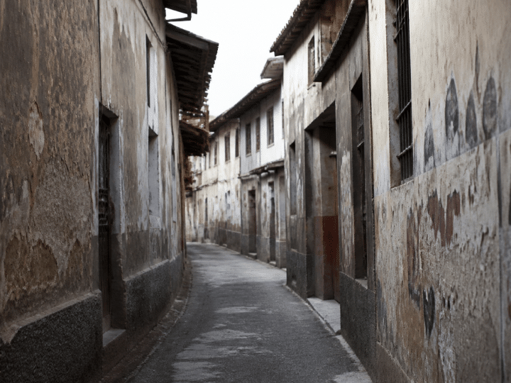Rue etroite avec facades degradees et graffitis sur murs