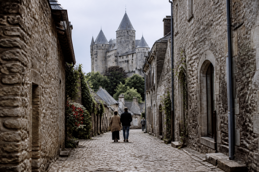 Rues pavees du centre-ville avec commerces et château historique visible