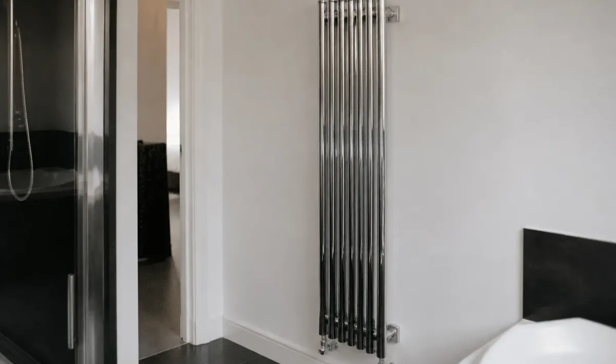 Radiateur chrome vertical fixe au mur blanc salle bain