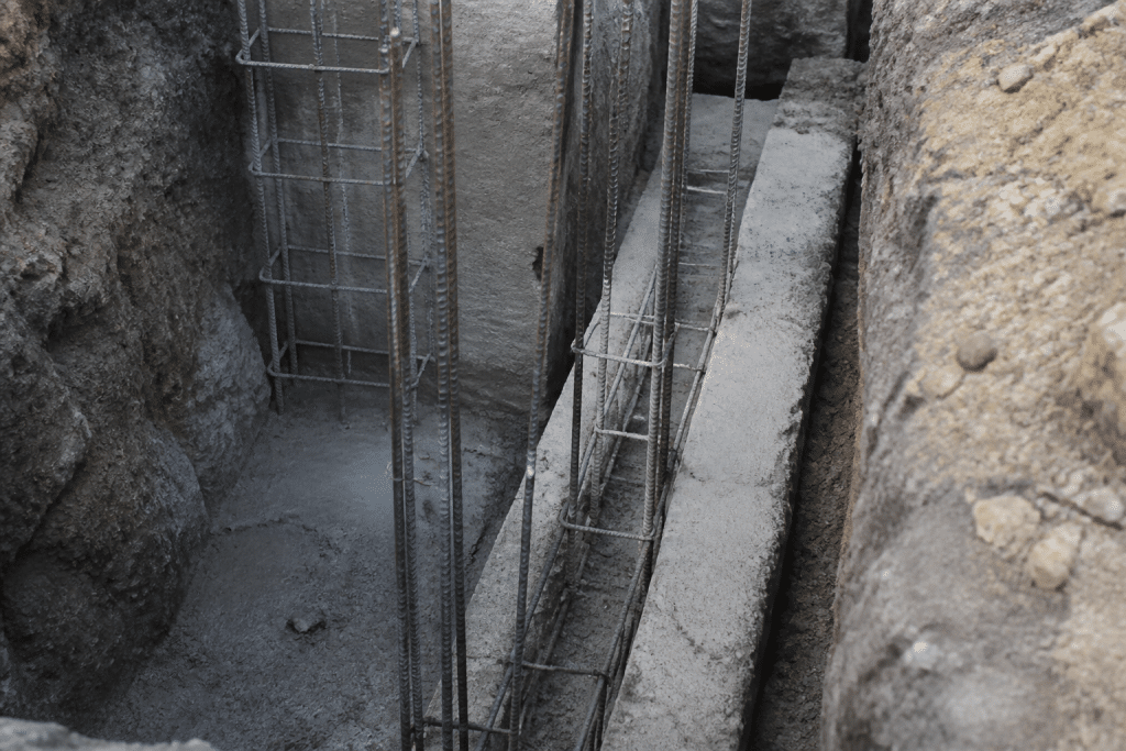 Tranchee profonde avec beton coule et armature metallique visible