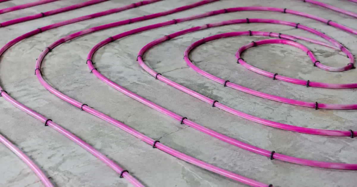 Tuyaux chauffants roses enroules en spirale sur dalle beton