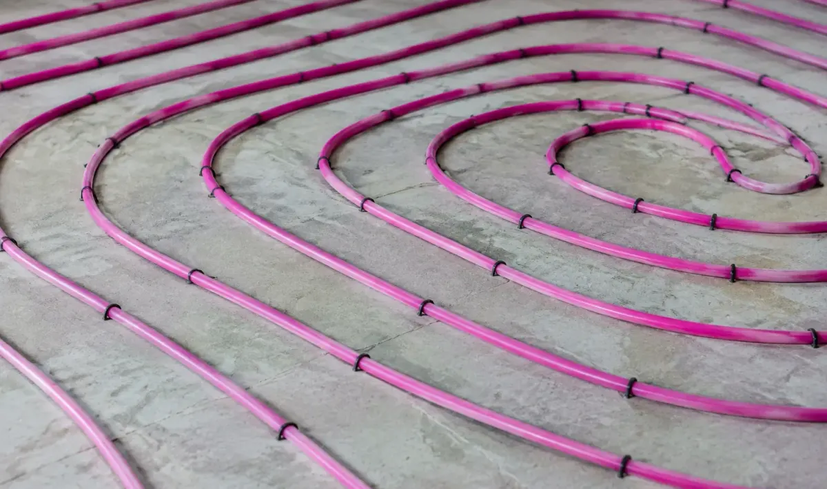 Tuyaux chauffants roses enroules en spirale sur dalle beton