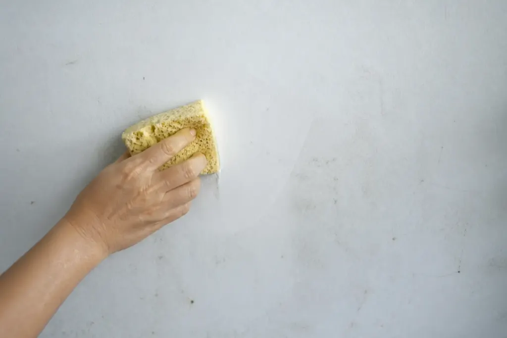 eponge humide sur mur blanc sale poussiere