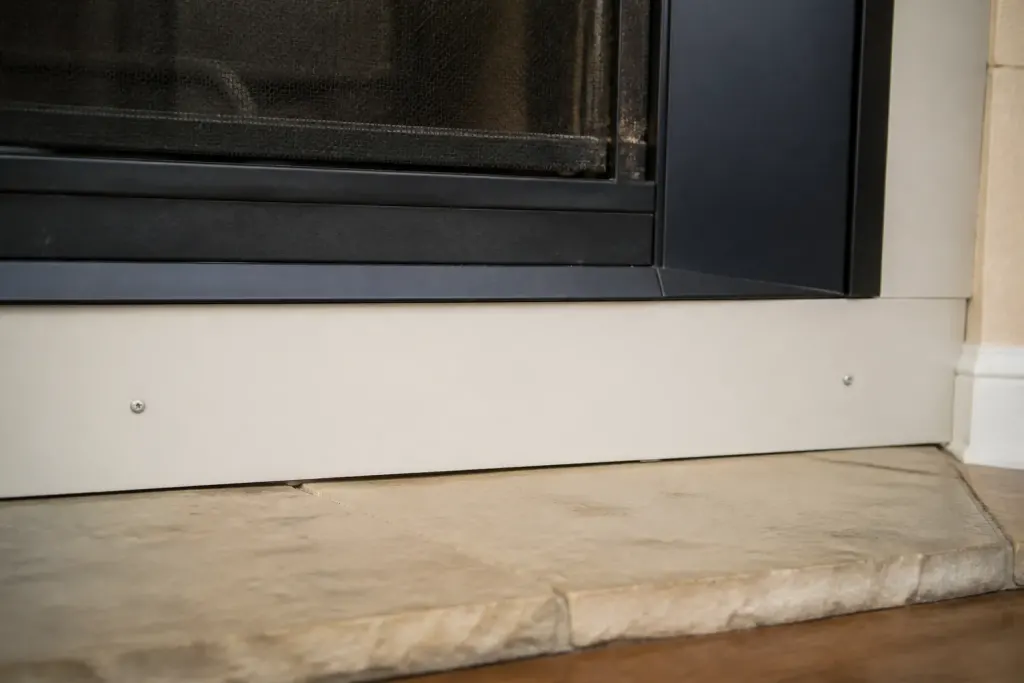Plaques rigides claires fixees par vis pres du foyer